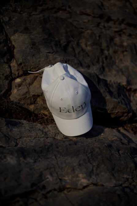 White Edlen cap with embroidered logo on weathered rocky surface