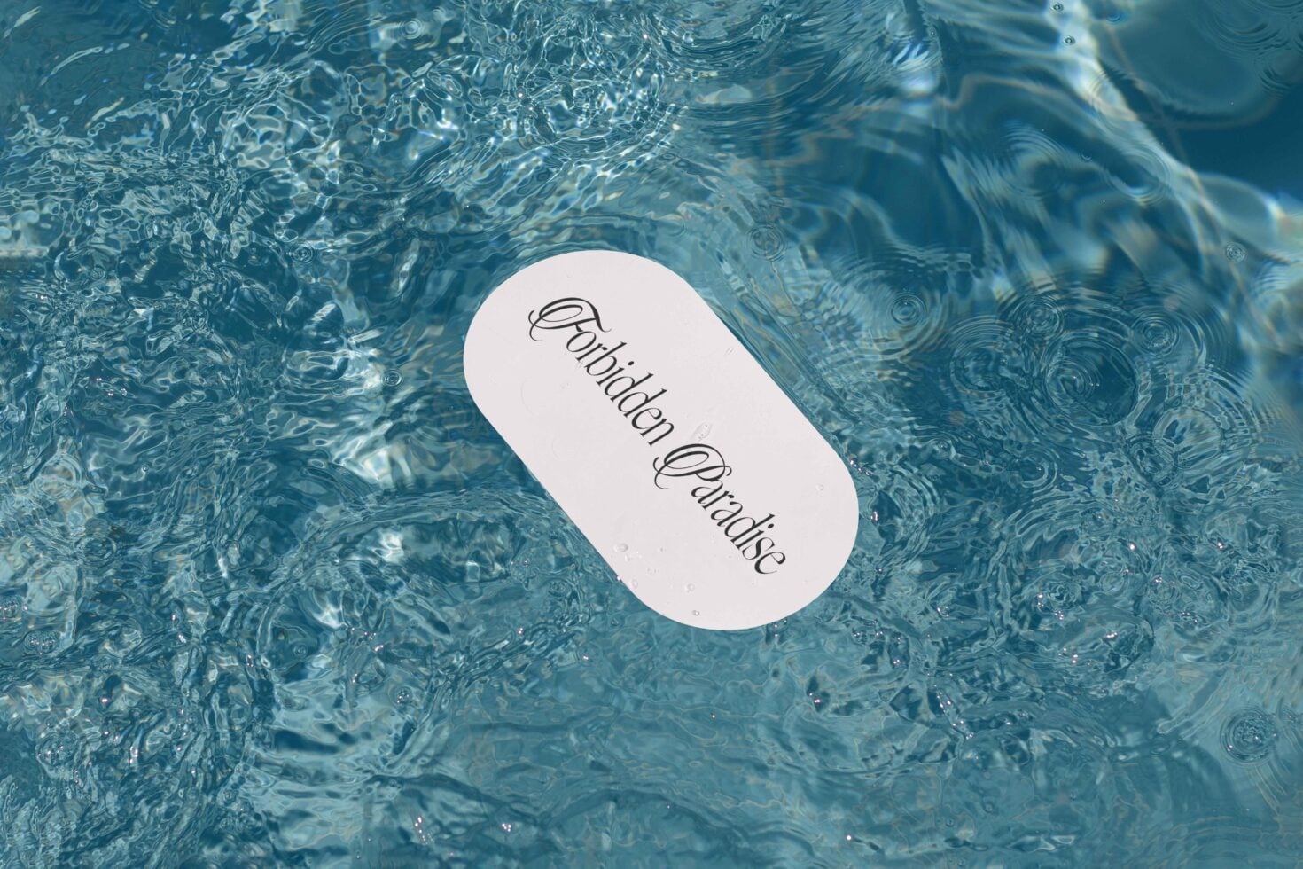 White rounded label mockup sitting on rippling water with light reflections