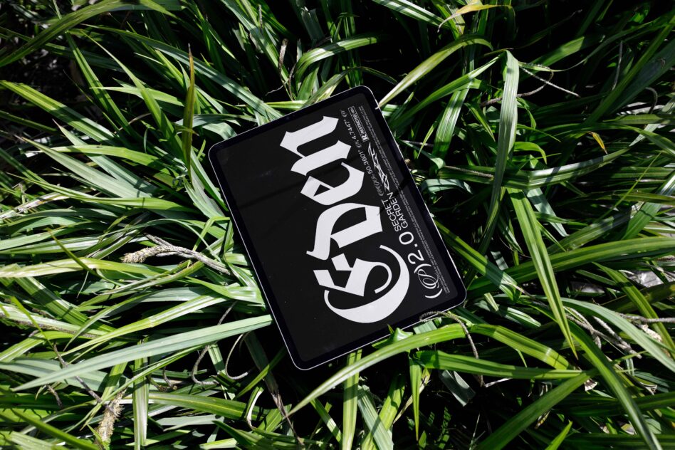 Tablet displaying serif letters nestled in vibrant green foliage overhead view