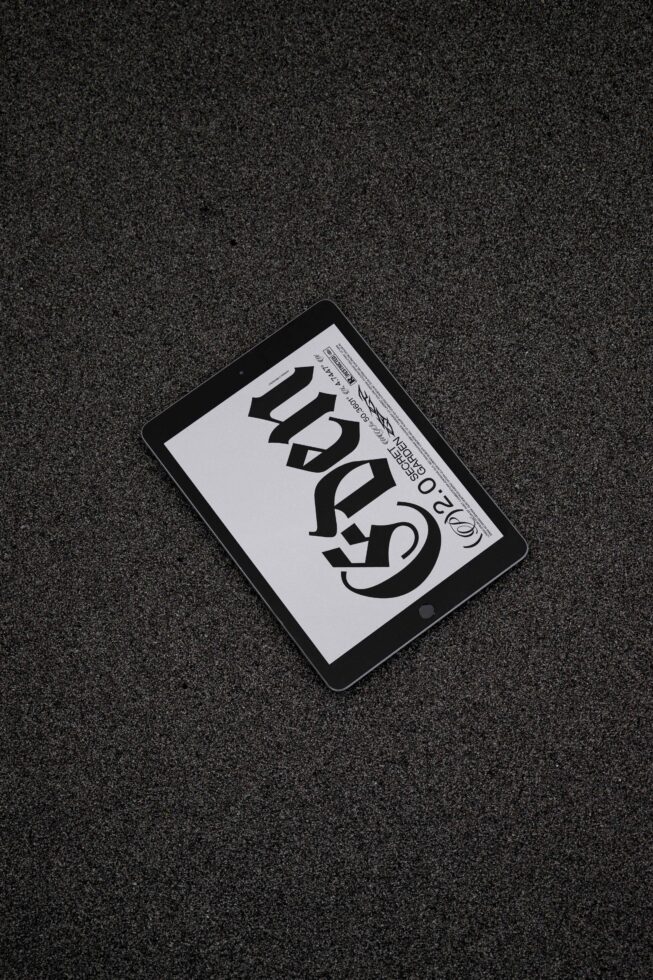 Tablet on textured surface displaying bold typography design ideal for designers seeking graphic inspiration and typography mockups in digital design.