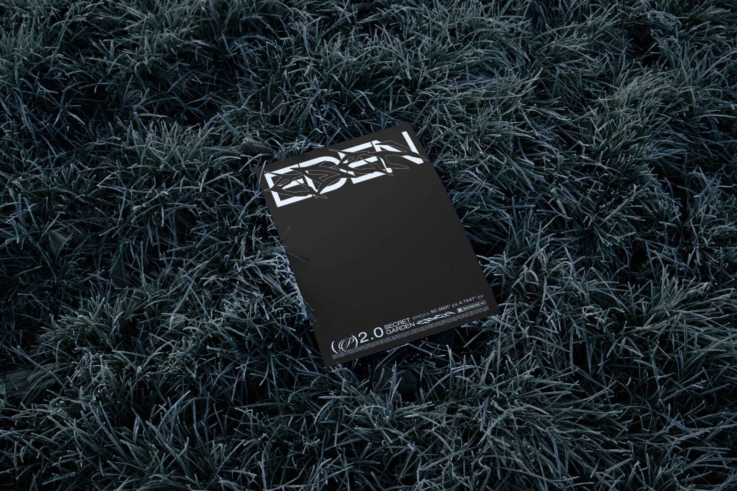 Black box with white geometric logo on frost-covered grass