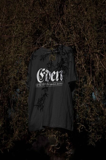 Black oversized shirt displayed on willow tree with dappled shadows