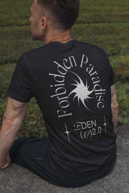 T-shirt mockup featuring a man seated outdoors wearing a dark tee with Forbidden Paradise graphic and unique typography perfect for graphic designers and templates.