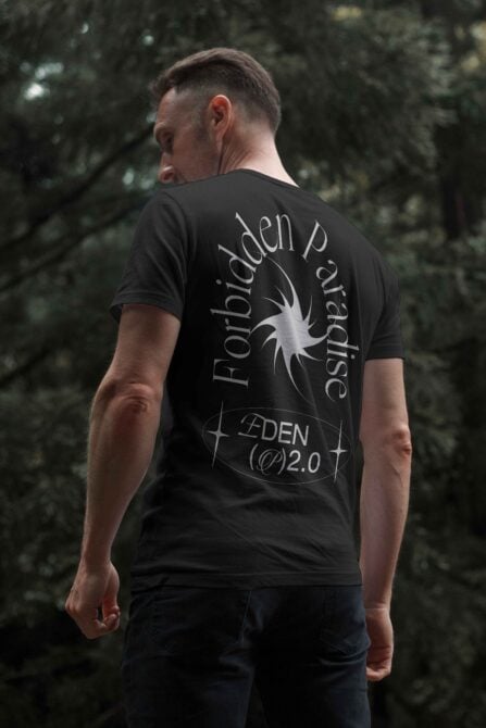 Man wearing a black t-shirt with gothic font design standing outdoors. The shirt reads Forbidden Paradise and Eden 2.0. Perfect for mockup templates.