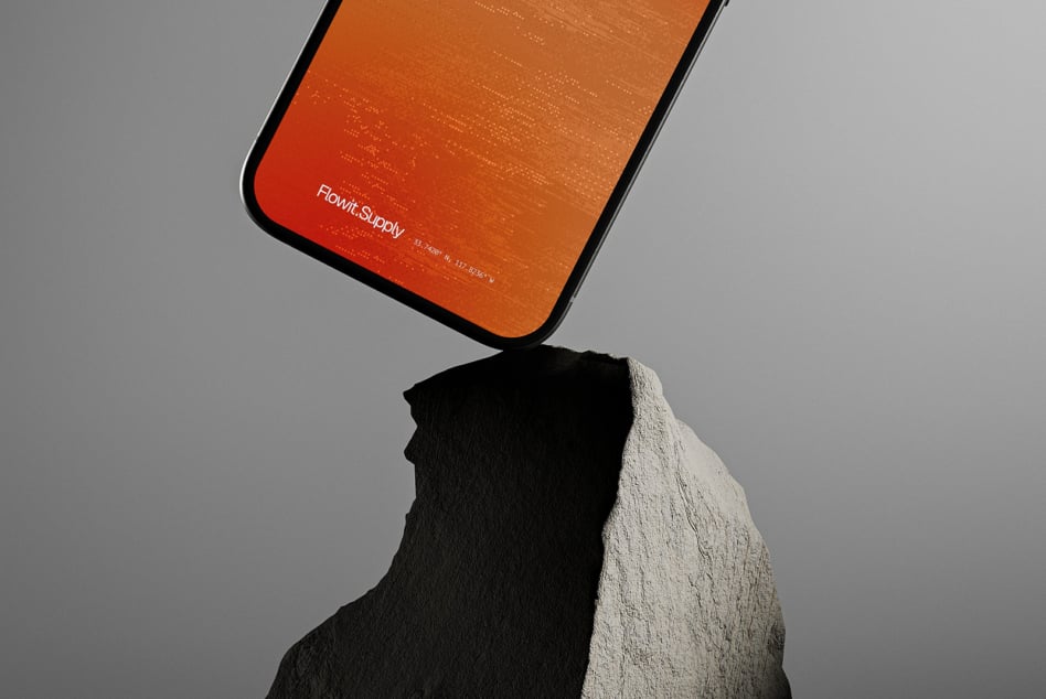 Stylish smartphone mockup resting on a rock with sleek orange display for digital design presentations. Ideal for showcasing app interfaces to designers.