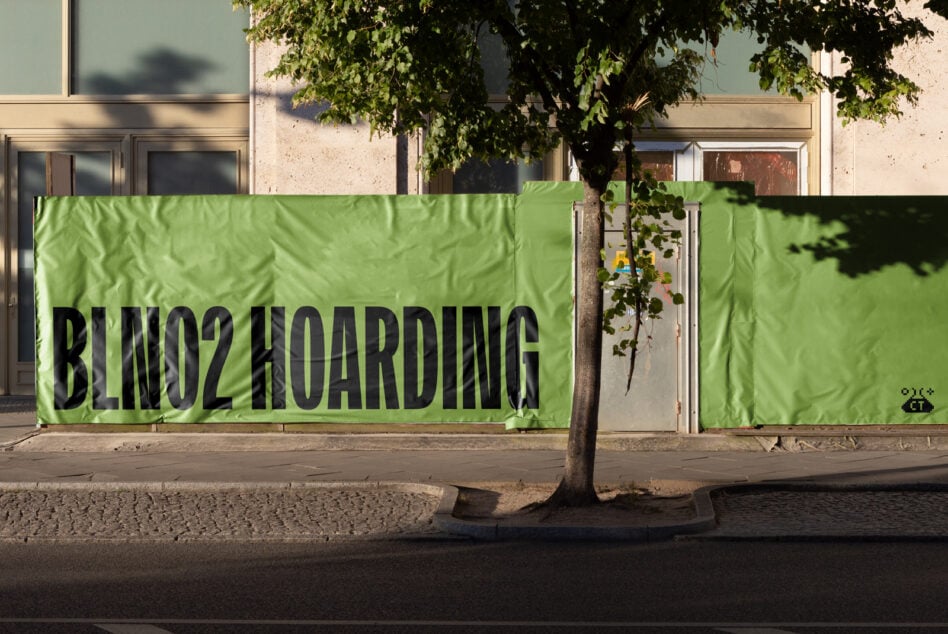 Bright lime green construction hoarding mockup with bold black lettering on urban facade