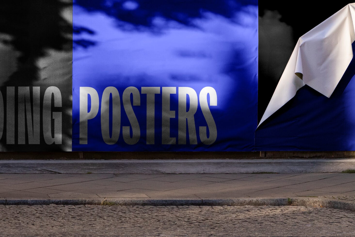 Blue hoarding mockup with white text saying POSTERS, white fabric corner peeling back