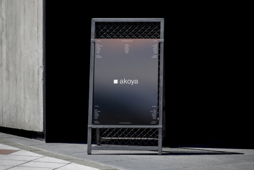 Mockup of a minimalist outdoor stand with a dark gradient poster displaying the word akoya perfect for showcasing modern branding in urban settings.