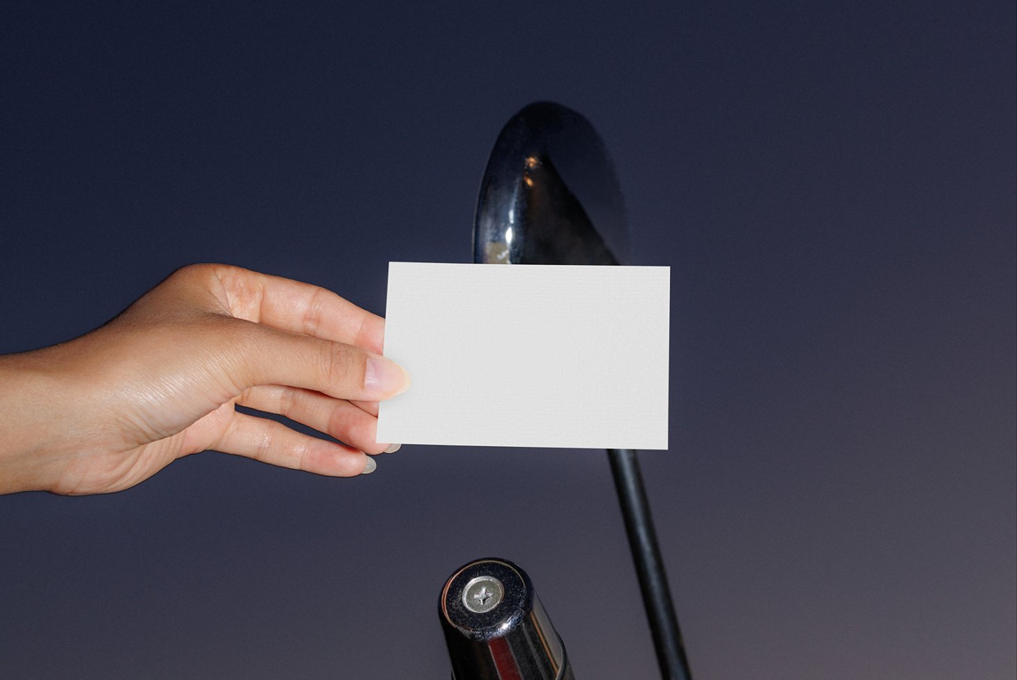 Hand holding blank business card mockup against a dark background ideal for templates branding or design presentations realistic lighting photo