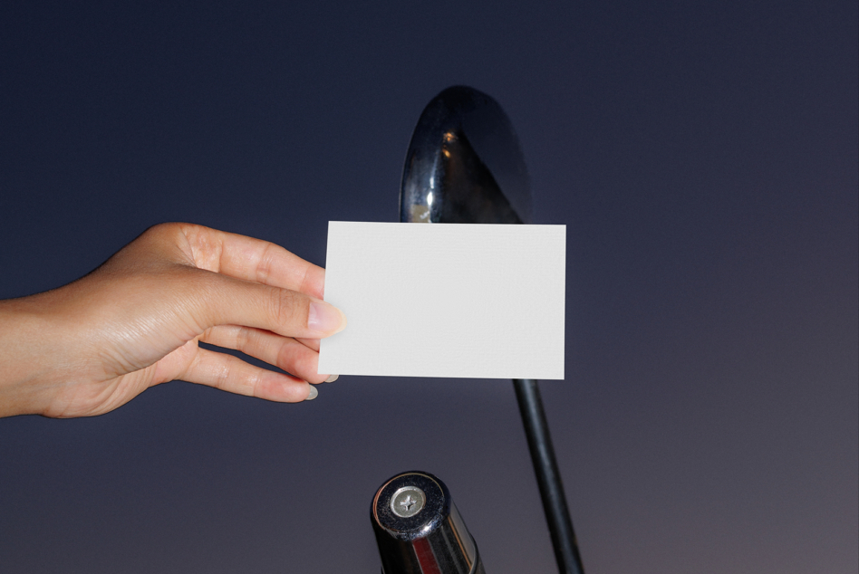 Hand holding blank business card with vintage compass in frame
