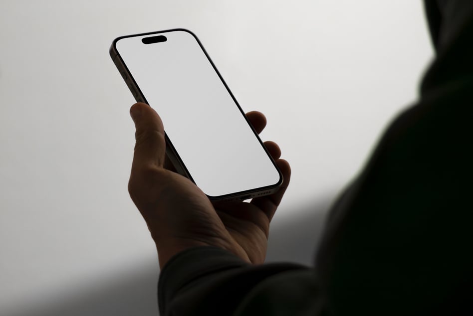 Mobile phone mockup held in a hand with blank white screen for presenting app designs digital templates ideal for graphic and UI designers.