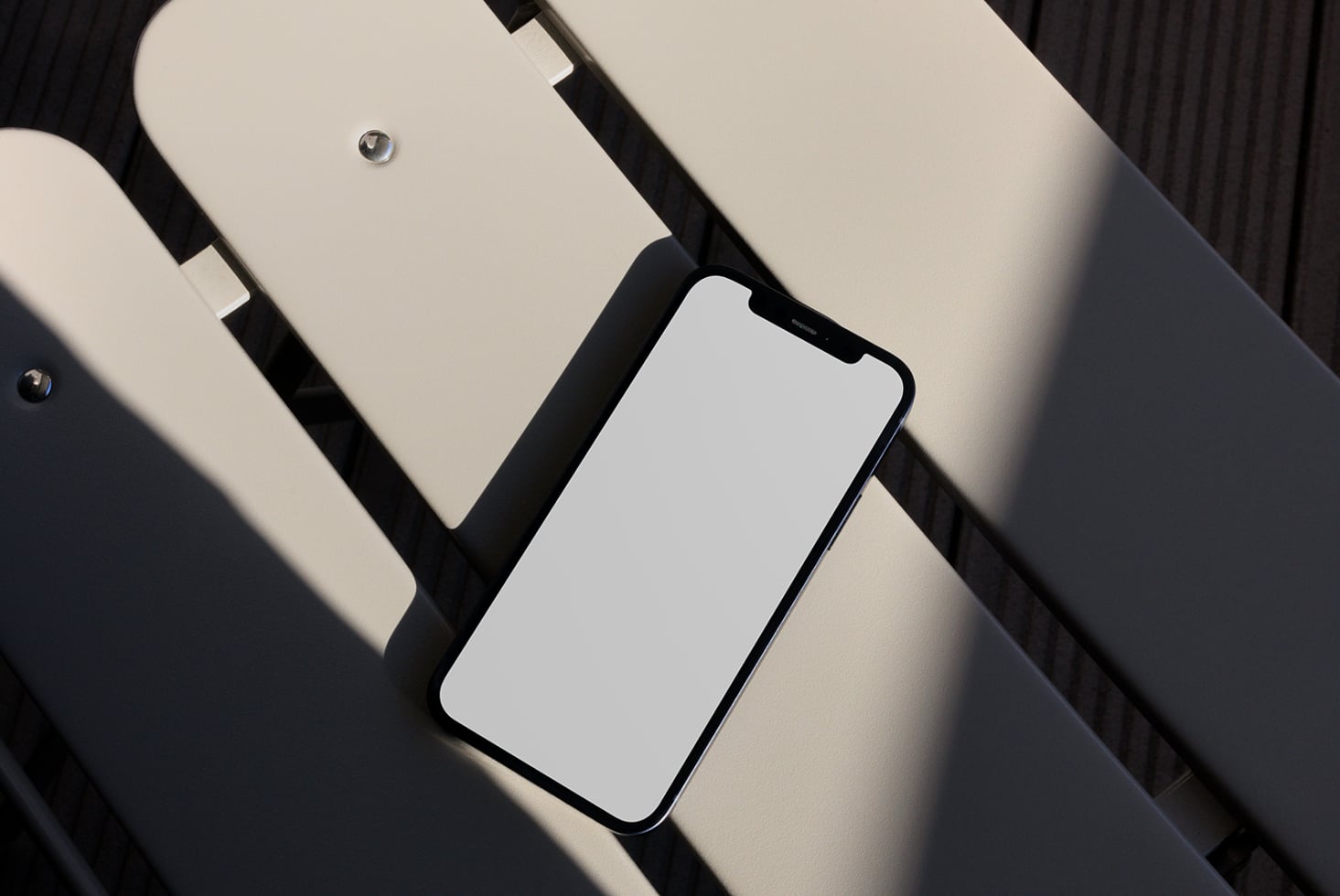 iPhone with blank screen on diagonal striped background with soft shadows