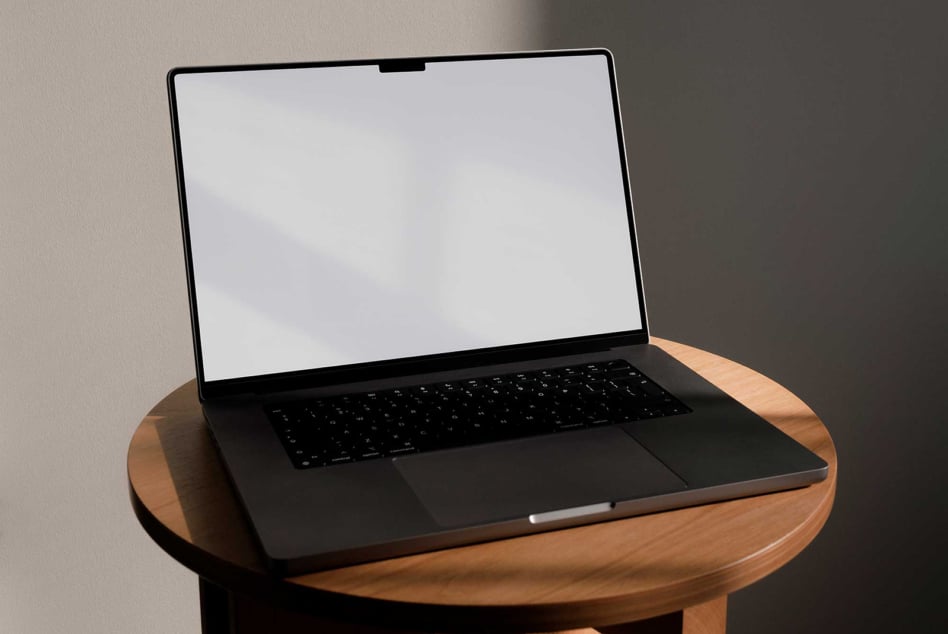 Laptop mockup on a round wooden table, blank screen for design display. Perfect for showcasing templates, graphic design, or digital presentations.
