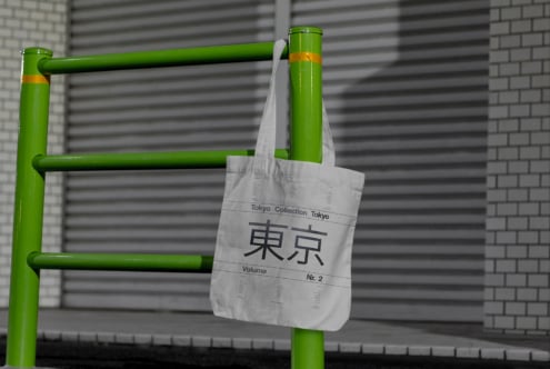 Urban tote bag mockup featuring Tokyo typography design hanging on vibrant green bar; perfect for designers and graphic projects seeking modern style.