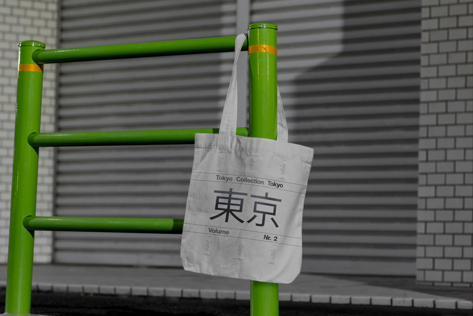 Light canvas tote bag on green pipes with Tokyo Collection kanji typography