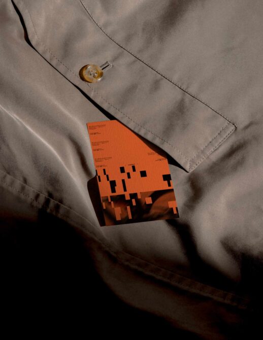 Orange business card mockup tucked in beige jacket pocket with horn button