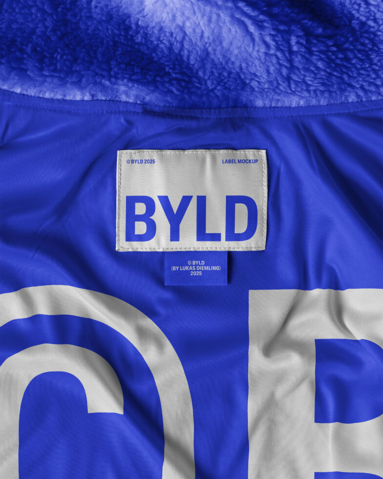 Mockup of a label design on a blue fabric texture featuring the text BYLD. Ideal for showcasing branding, textile design and fashion projects.