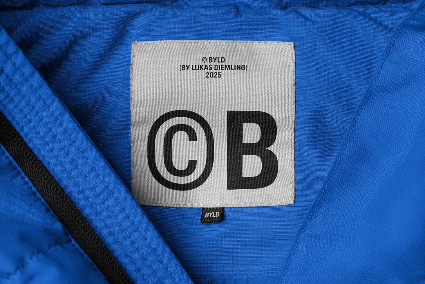 Blue fabric with stitched label featuring bold font CB for branding concept. Ideal for graphic design, typography template, textile mockup.