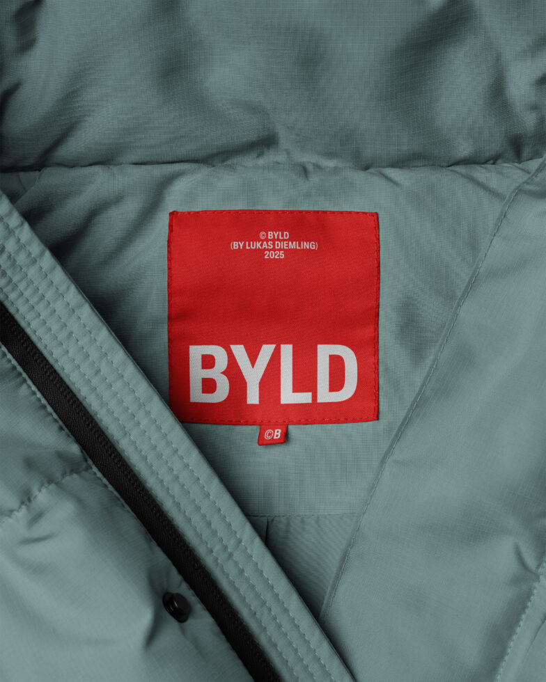 Green jacket with a red BYLD label, showcasing product branding. Ideal for fashion mockups or design templates. Optimize your creative projects.