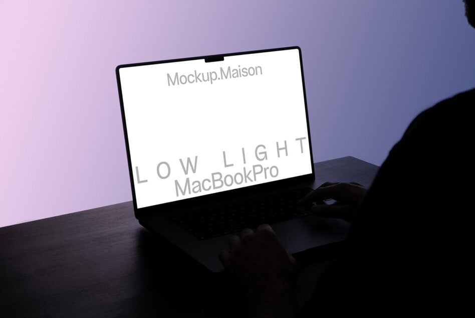 Person typing on MacBook Pro with gradient pink blue backdrop