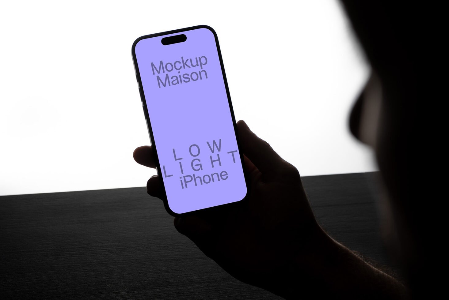 iPhone mockup in low light setting held by silhouetted hand showcasing minimalist design perfect for designers seeking sleek mobile templates.