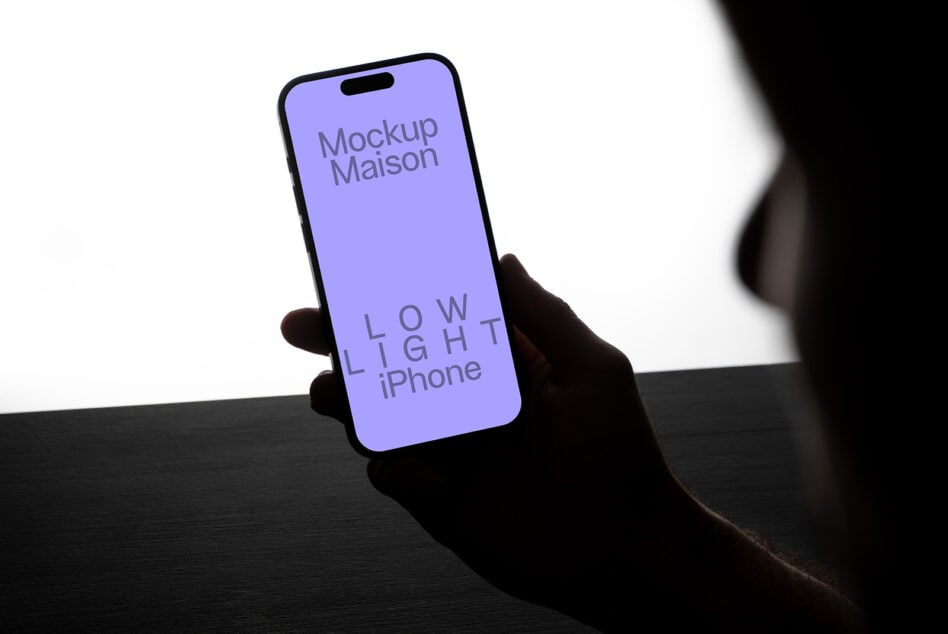 iPhone mockup in low light setting held by silhouetted hand showcasing minimalist design perfect for designers seeking sleek mobile templates.