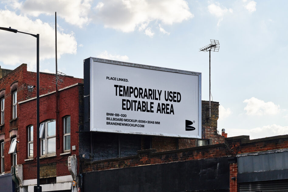 Large white billboard on brick building rooftop with sky backdrop