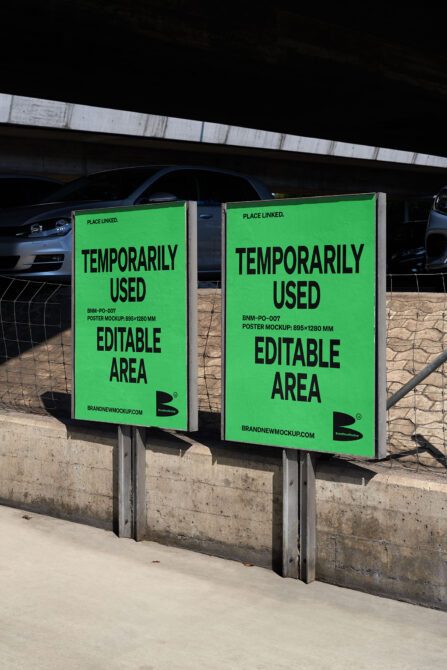 Pair of bright green poster mockups on concrete base under parking lot overhang