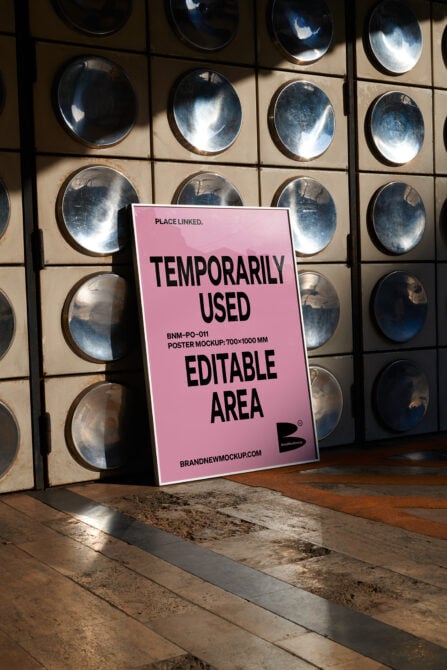 Pink poster mockup tilted against metal plate display with black typography