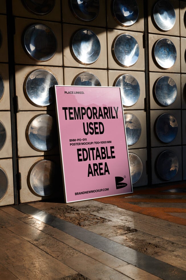 Pink poster mockup tilted against metal plate display with black typography