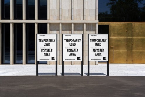 Urban outdoor poster mockup template showcasing three standing white posters with editable content for graphic designers modern building background