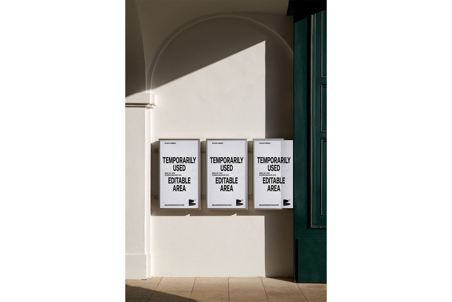 Three framed white posters mounted on beige wall below curved arch, minimal shadows