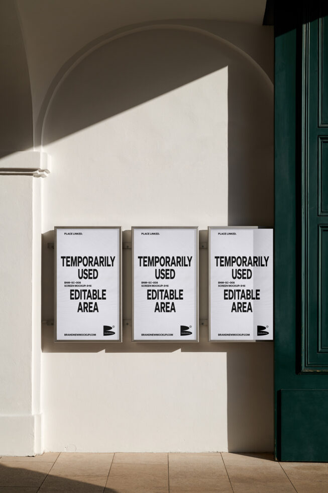 Three framed white posters on beige wall beneath curved arch with green door on right