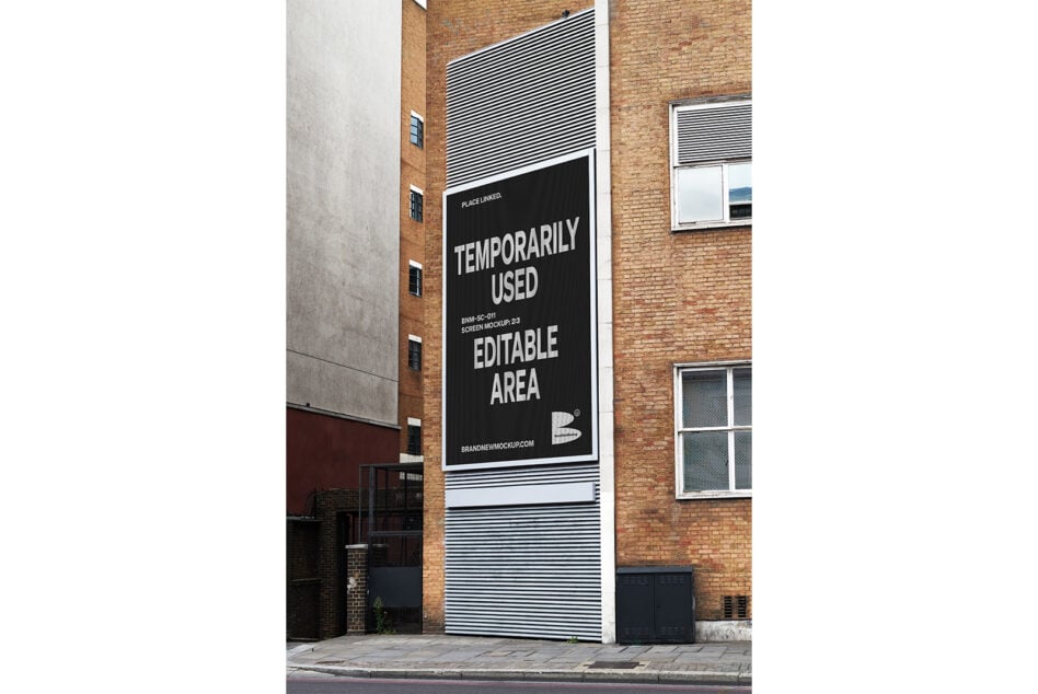 Black building screen mockup on brick wall with striped design, ready to edit