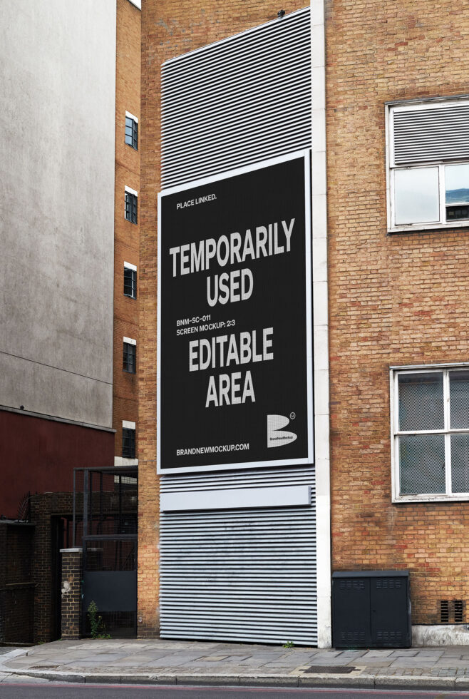 Large black poster on red brick building facade with white striped pattern above it