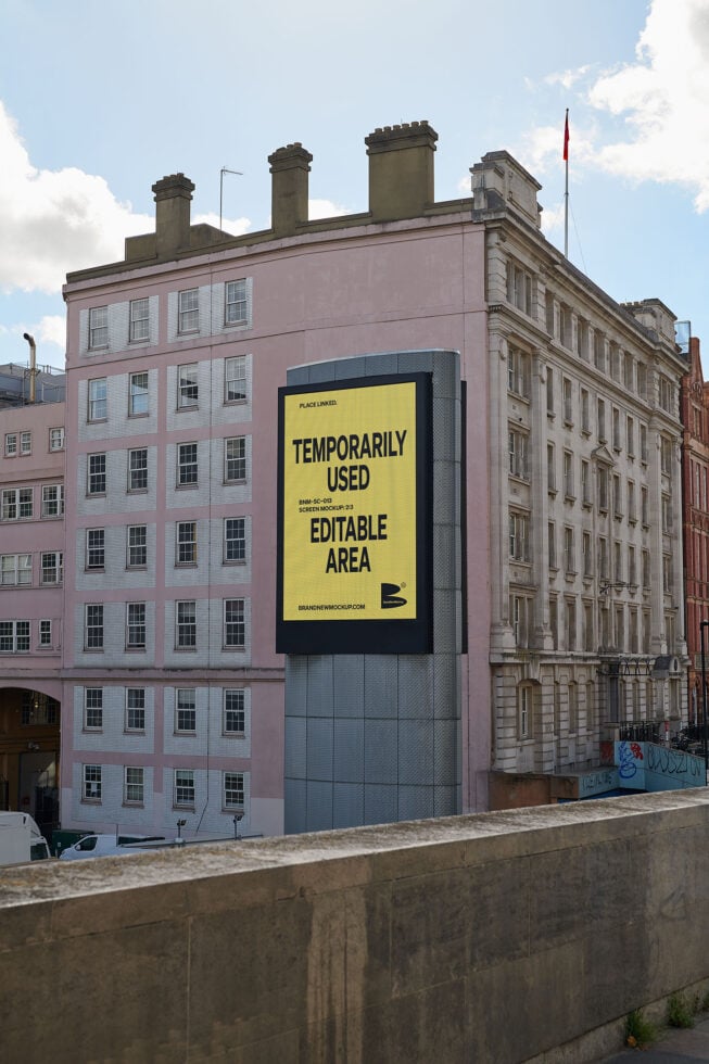 Urban billboard mockup on building facade with editable content area promoting design assets for digital creators and marketing professionals.