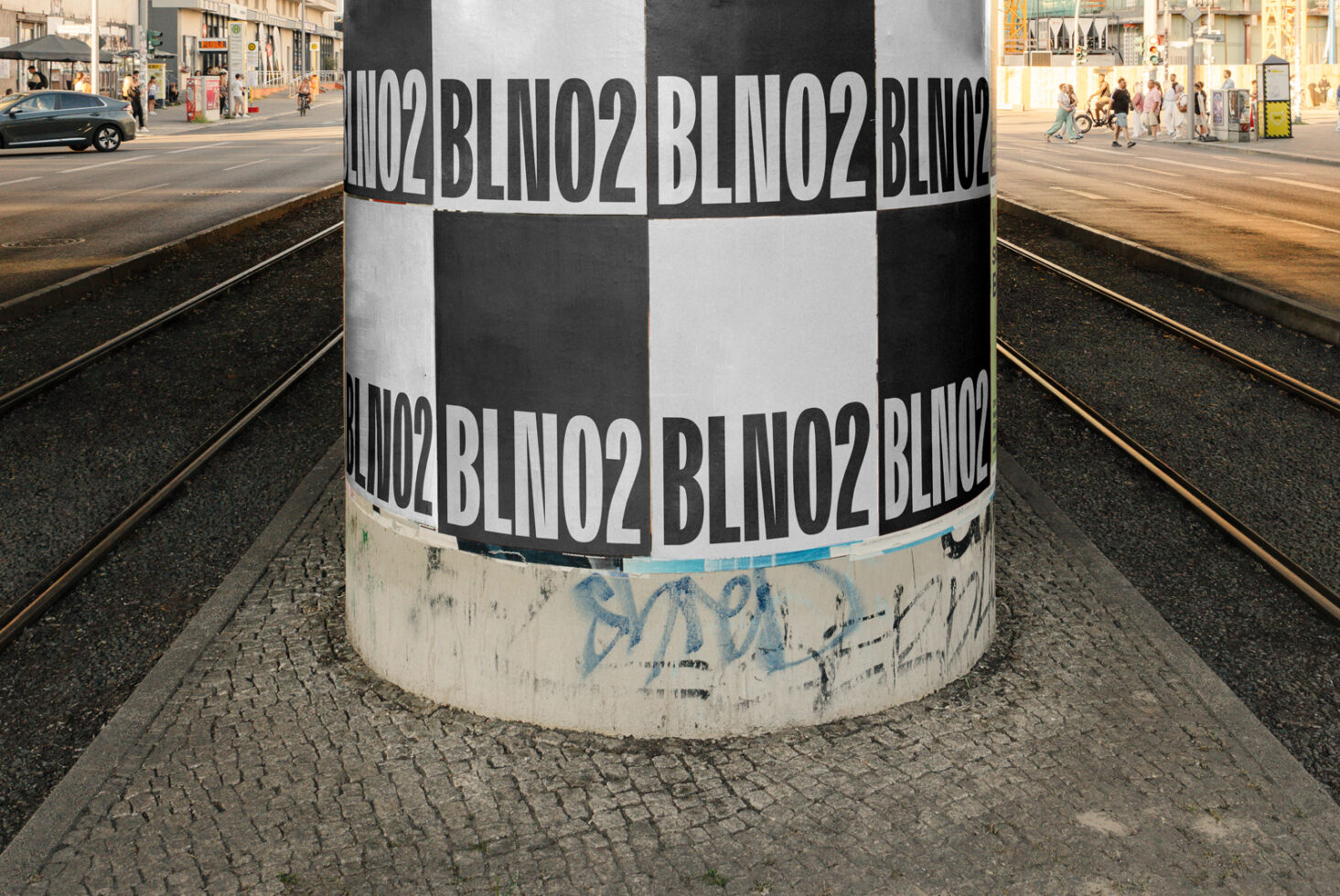 Striped pole wrapped with repeated black text in urban plaza street view