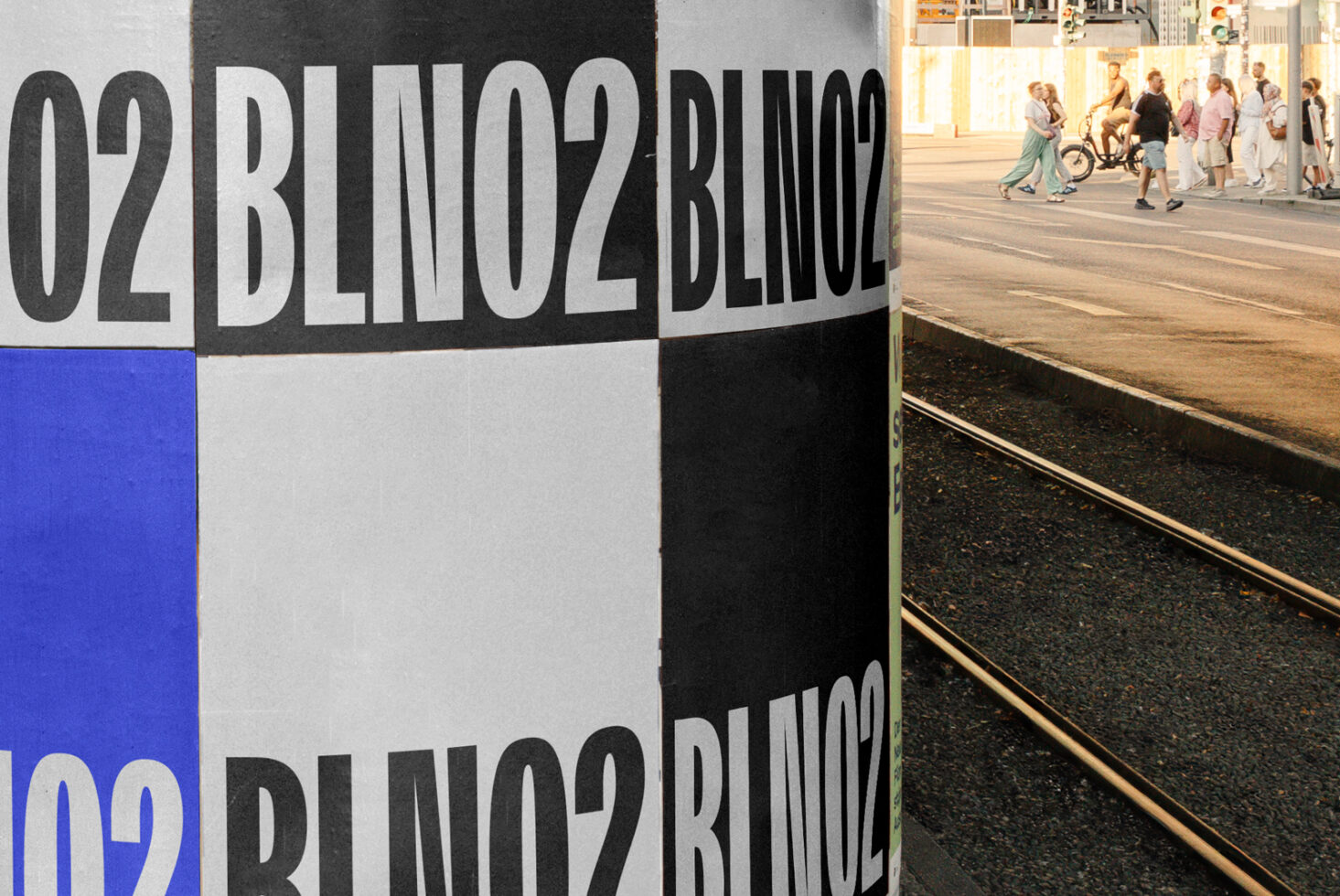 Colorblock street bollard showing blue white black sections with large typography wrap