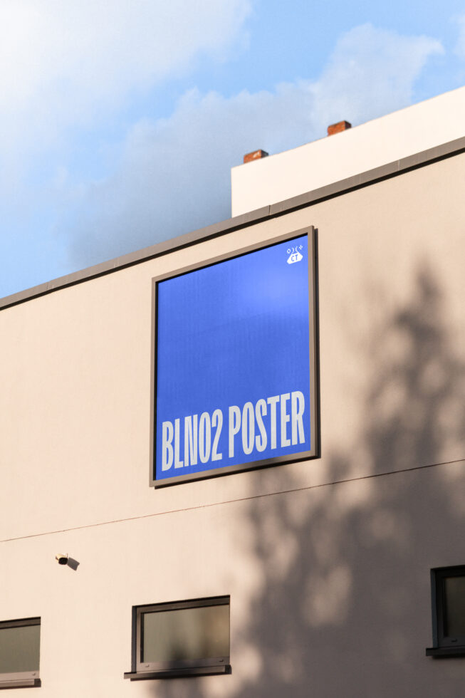Framed blue poster on cream wall with white text reading BLINO2 POSTER, outdoor shadow