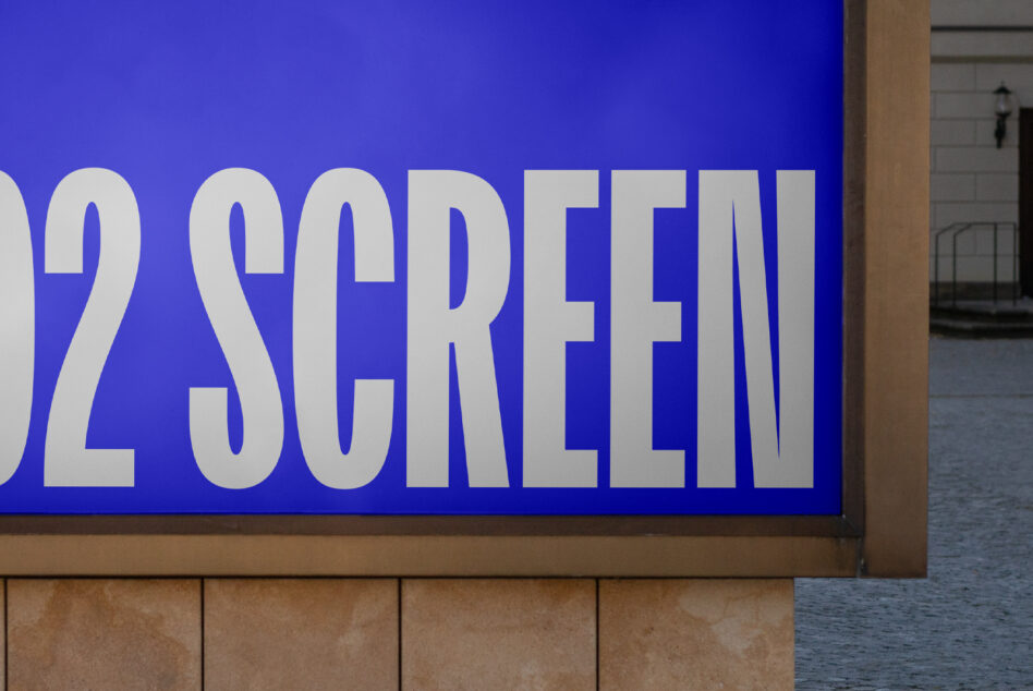 Bright blue storefront sign with large white sans-serif text on stone building