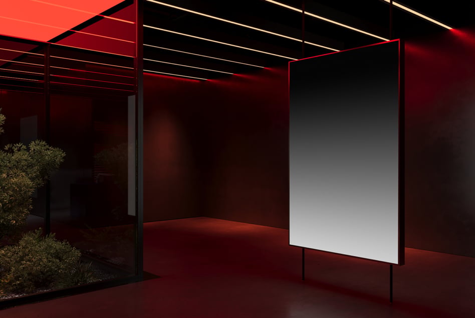 Sleek dark showroom with red neon trim, black framework, illuminated blank display panel, plants