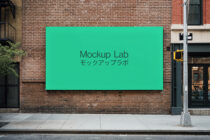 Solid teal rectangular billboard on exposed brick street facade mockup