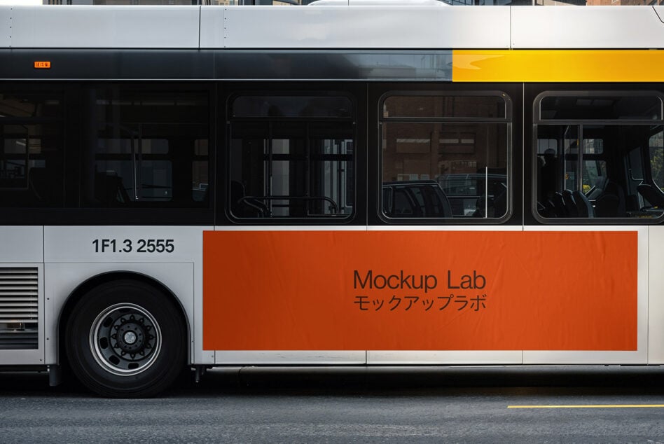 Side view of a city bus with a custom orange banner displaying Mockup Lab text. Ideal for designers needing realistic advertising mockups. Bus graphics.