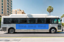 Bus exterior mockup showing blue banner with repeated Mockup Lab branding