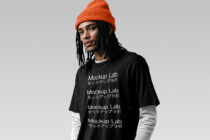 Dude in bright orange beanie wearing black oversized tee with stacked Mockup Lab copy