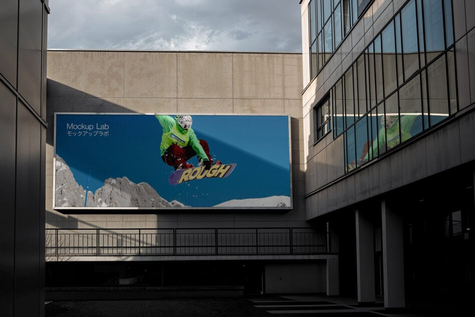 Urban billboard mockup featuring a vibrant snowboarder against snowy mountains for design presentations. Perfect for showcasing advertising graphics.