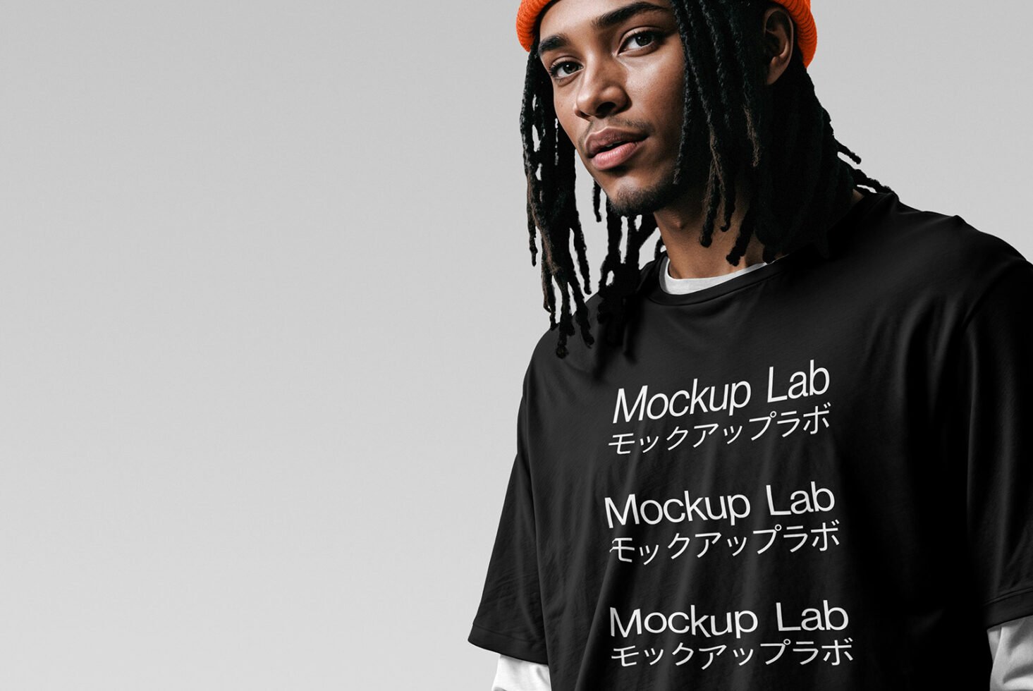 Young man wearing black T-shirt with Mockup Lab text. Perfect for apparel mockups and fashion design projects. White background. Graphic resource.