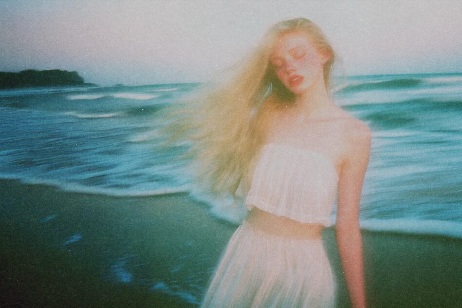 Dreamy blurred photo of a woman on the beach with flowing hair. Perfect for designers needing ethereal graphics or creative templates. Ocean backdrop.
