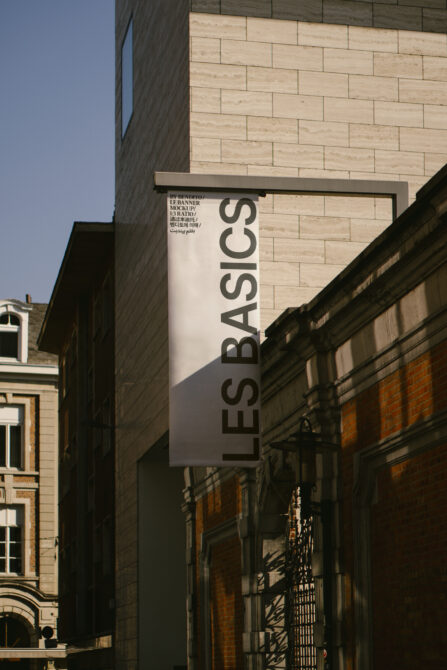 Vertical light banner mockup on building exterior between architectural elements