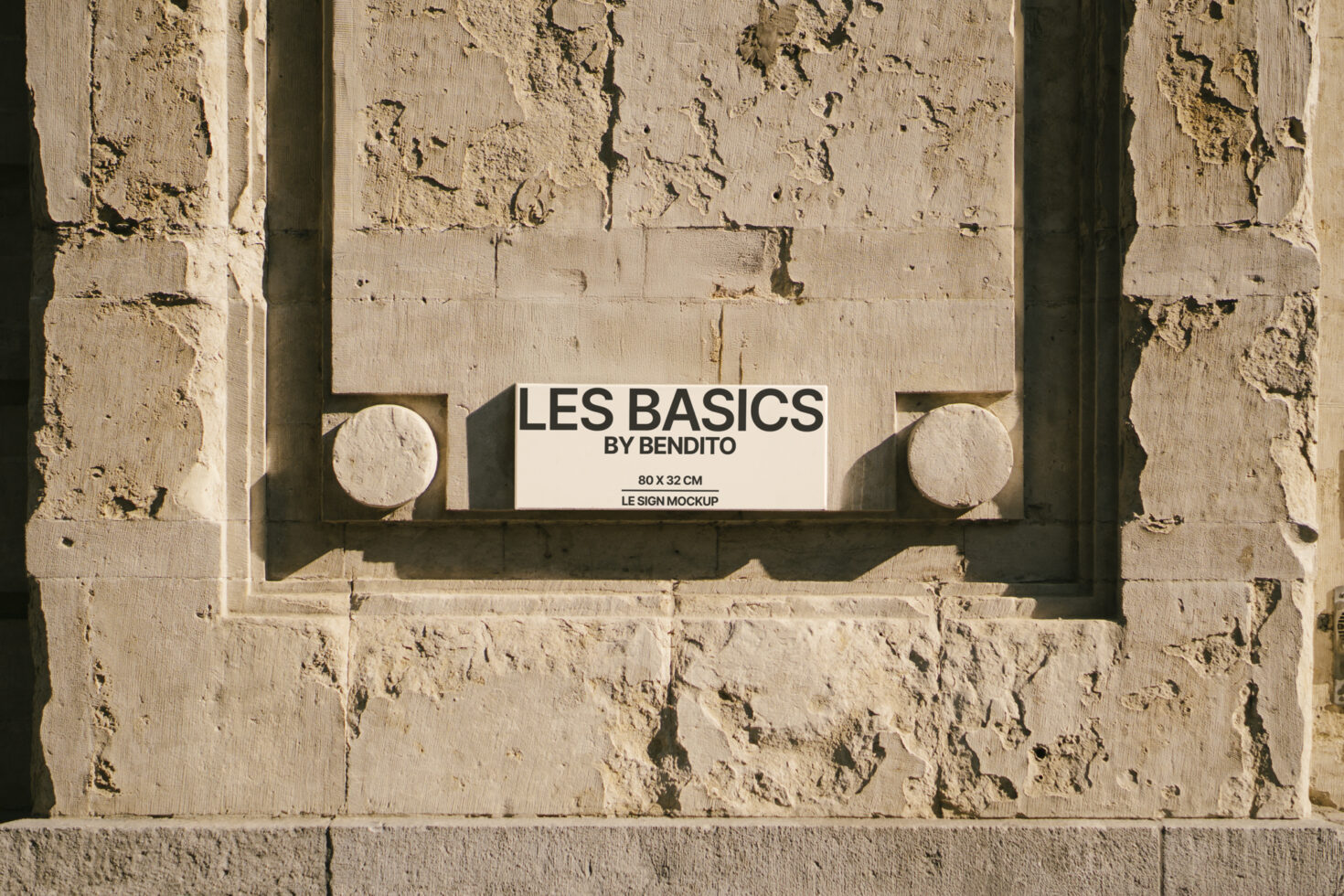 Stone texture wall with an embedded rectangular sign mockup reading LES BASICS by Bendito. Ideal for design template presentations and branding graphics.